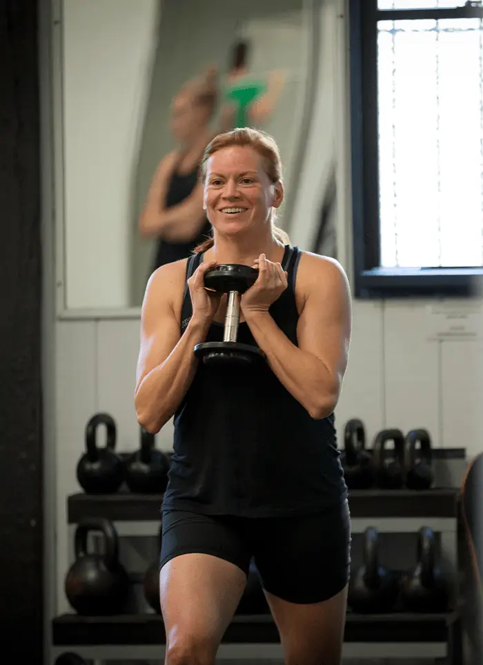 A QSMC client during an Exercise Physiology appointment performing lunges with a dumbbell weight