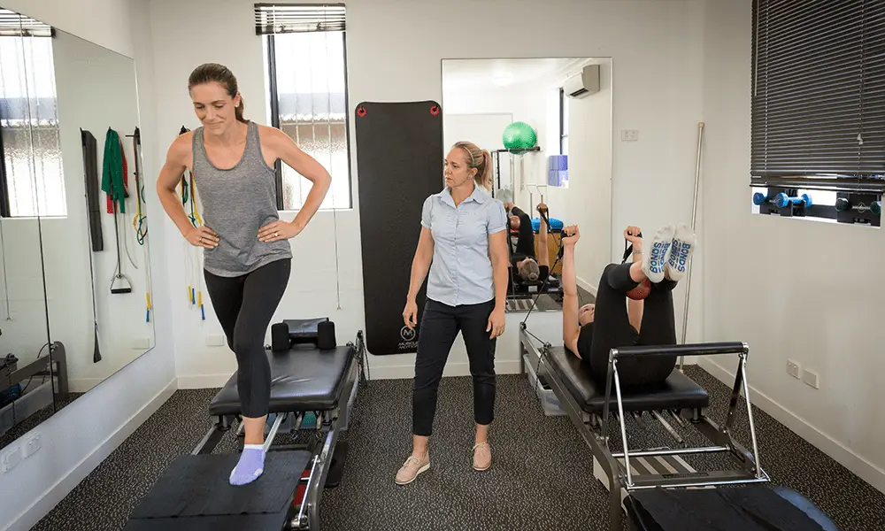 Two QSMC clients during a pilates session with Physiotherapist, Mardi Watson