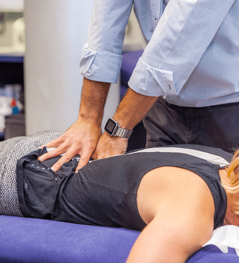 A practitioner giving remedial massage treatment to a client's lower back