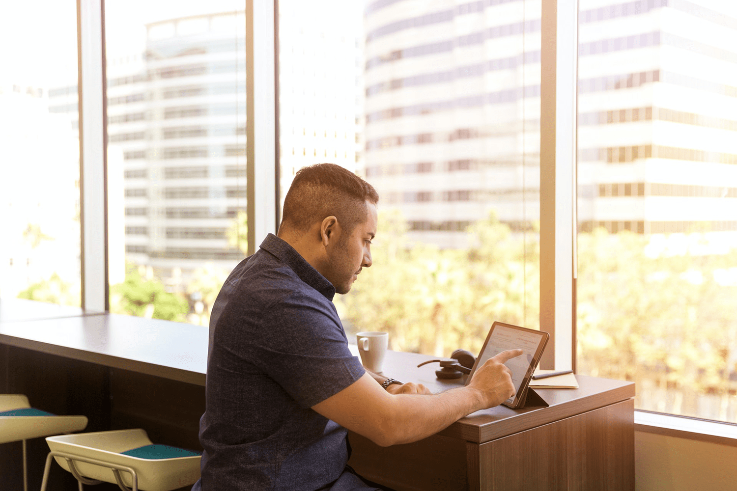 Picture of a man sitting by a window using an iPad