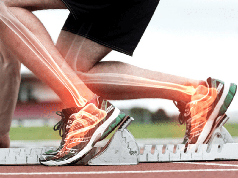 Image of an athlete in track and field starting blocks with the bone anatomy highlighted