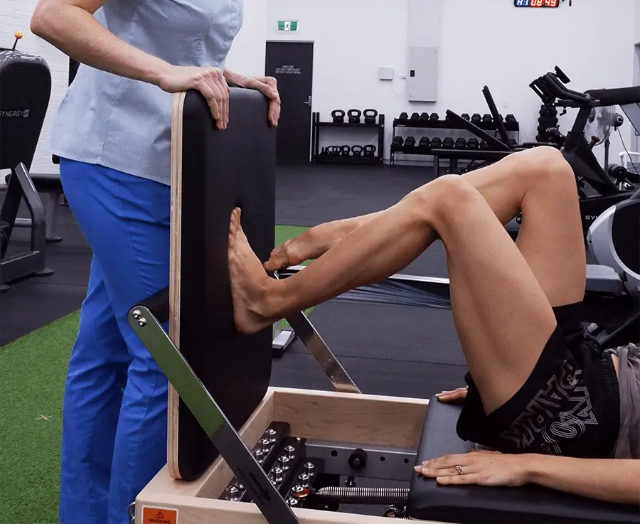 A ballet dancer performing exercise on a pilates reformer while in a dance physiotherapy appointment with Dr Melanie Fuller
