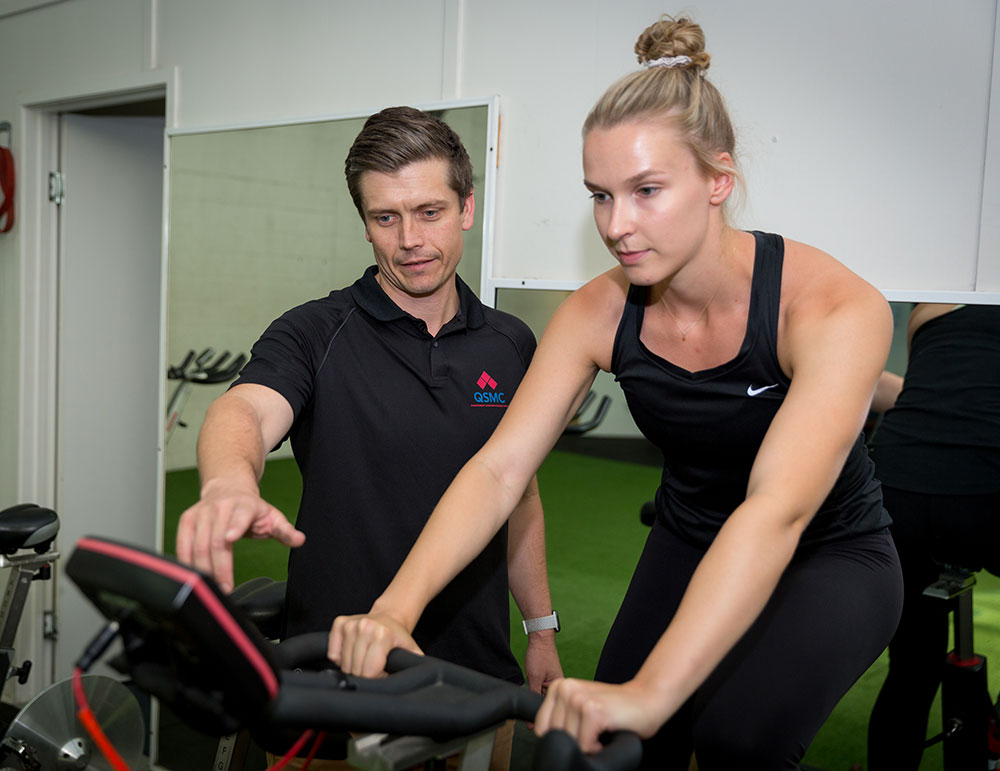 Senior Exercise Physiologist Adam Garred supervising a client on a bike during an EP appointment