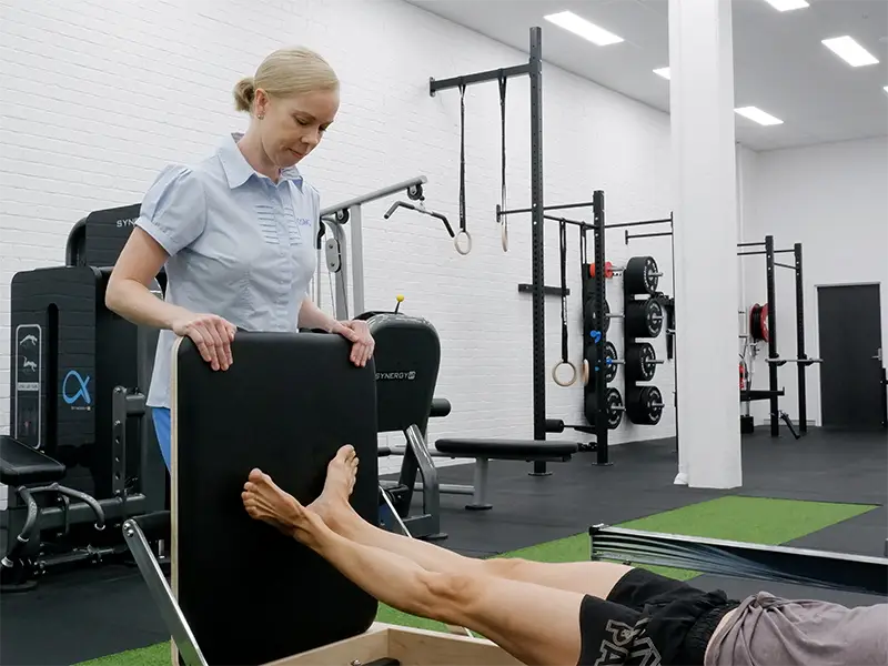 Melanie Fuller watching over a ballet dancer doing exercise on the reformer machine